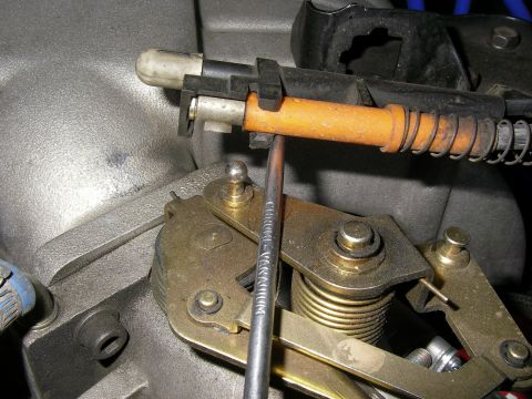 1990 Ford Bronco - Close-up of a throttle linkage mechanism, showing the cable and associated hardware.