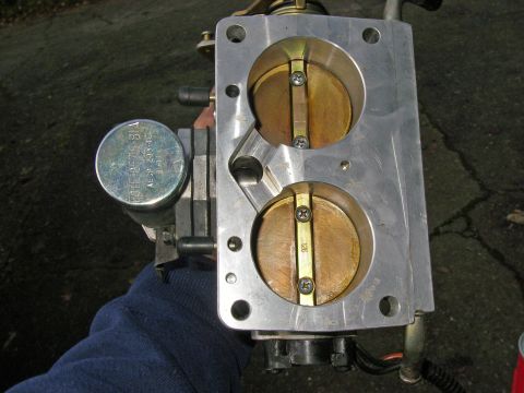 1990 Ford Bronco - This is a throttle body assembly, likely from an older vehicle, with visible text on a component cap.