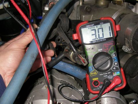 1990 Ford Bronco - Testing resistance with a multimeter in an automotive engine bay.