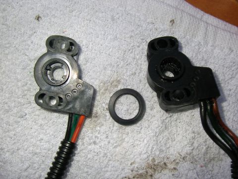 1990 Ford Bronco - Disassembled throttle position sensor components with a gasket are laid out on a textured white surface.