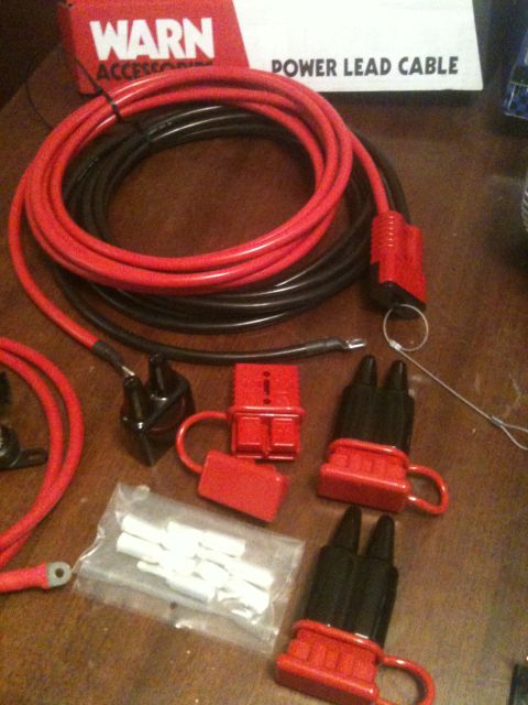 1996 Ford Bronco - Warn power lead cable and connectors are laid out on a wooden surface.