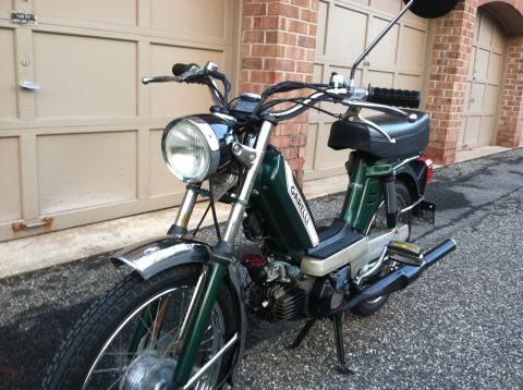 1981 Garelli Rally Sport - A green Garelli moped is parked in front of a brick building with a garage door.
