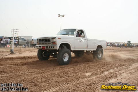 1995 Ford Bronco - A lifted white pickup truck competes in a sand drag race event.