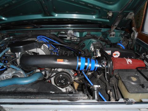 1990 Ford Bronco - The engine bay features a K&N air intake system with blue accents and visible hoses.