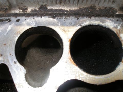 1997 Ford Taurus - Close-up view of an engine intake manifold, showing two circular ports with carbon buildup.