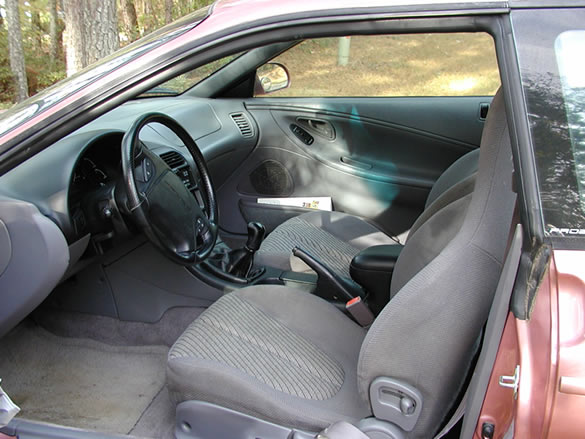 Interior front seats and dashboard of Ford Probe coupe with gray cloth upholstery