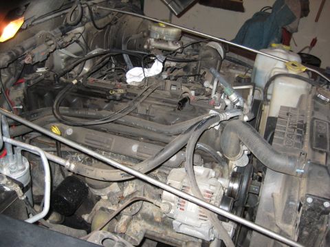 2005 Jeep Wrangler - The engine bay of a 2005 Jeep Wrangler is shown, revealing various components and wiring.