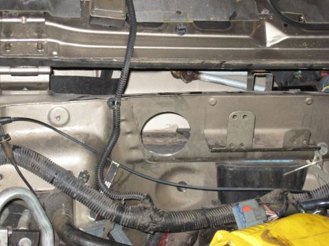 2005 Jeep Wrangler - This image shows a section of a vehicle's firewall, including various wires and a hole in the metal structure.