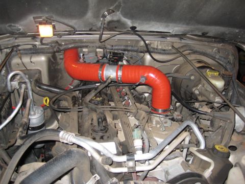 2005 Jeep Wrangler - Engine bay of a 2005 Jeep Wrangler showing a red aftermarket intake tube.