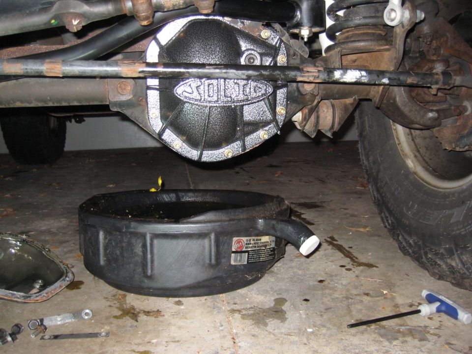 differential cover with "SOLID" logo, oil drain pan below