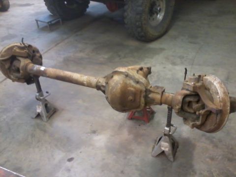 1995 Ford Bronco - Front axle assembly, likely from a 1995 Ford Bronco, is shown supported by jack stands.