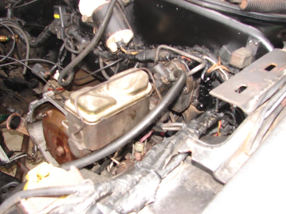 Engine bay view showing brake master cylinder, wiring, and hoses