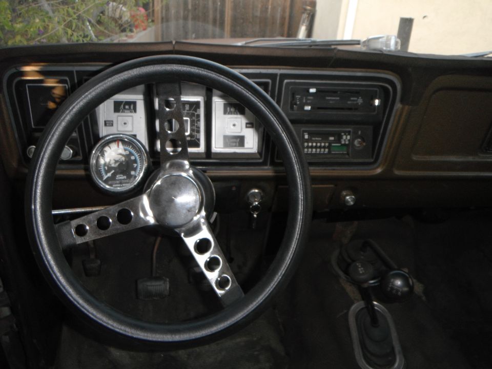1979 Ford Bronco interior with aftermarket steering wheel, gauges, and radio