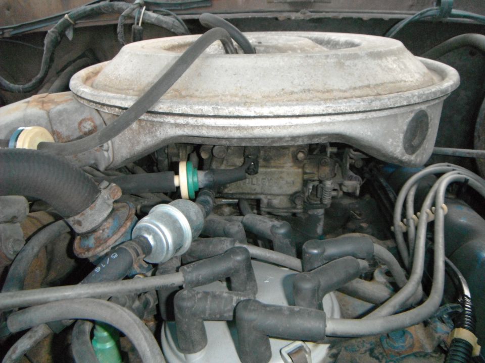 Engine bay showing carburetor and spark plug wires