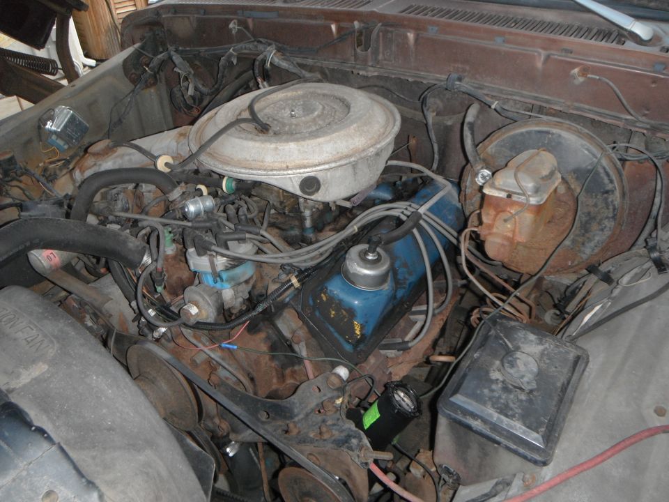 Engine bay with V8 engine, air cleaner, distributor, and brake master cylinder visible. Some rust present