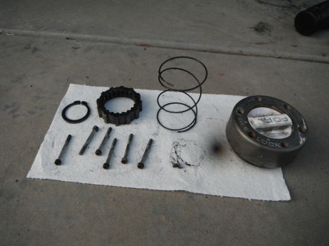 1979 Ford Bronco - Disassembled front hub assembly parts, including a Free Lock mechanism, are laid out on a paper towel.