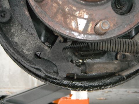 1979 Ford Bronco - Close-up view of a vehicle's drum brake assembly, showing the brake shoes, spring, and rotor.