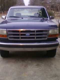 1995 Ford F-150 - Front view of a blue Ford F-150 pickup truck with a prominent grille and headlights.