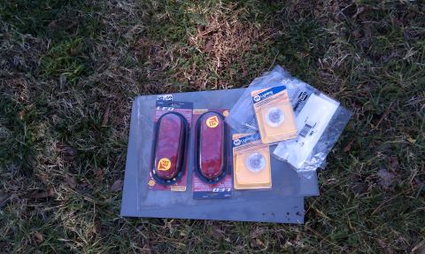 1979 Ford Bronco - New LED trailer lights and bulbs are laid out on a metal sheet on the grass.