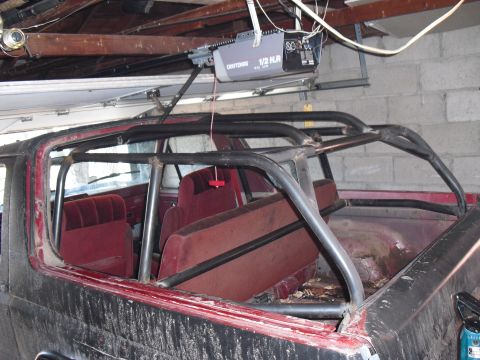 1986 Ford Bronco - The interior of a 1986 Ford Bronco shows red seats and a prominent roll cage.