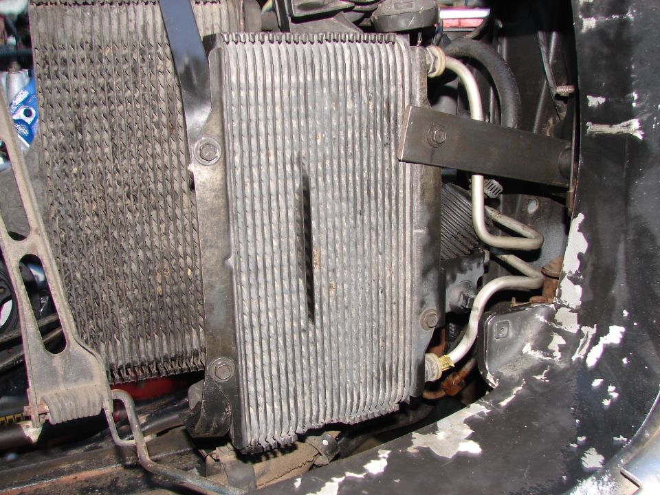 transmission cooler mounted next to a radiator, with hoses and brackets visible