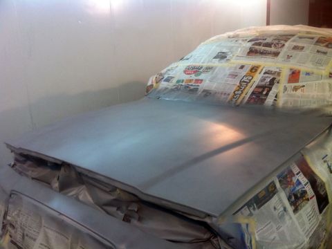 2001 Mercury Grand Marquis - A car's front end is prepped for paintwork, covered in newspaper and tape.