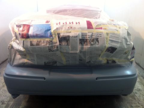 2001 Mercury Grand Marquis - The rear of a car is masked with newspaper and tape, likely in preparation for auto body work.