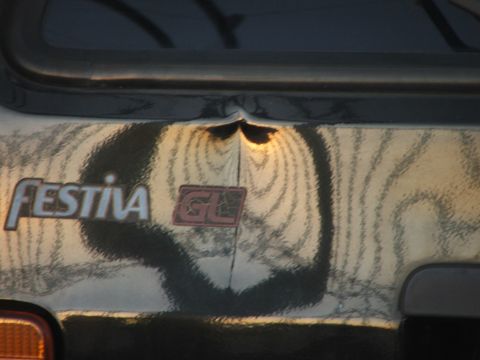 1991 Ford Festiva - The rear of a Ford Festiva GL shows a dented trunk lid with a "GL" badge.