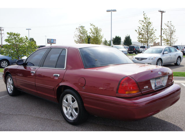 Red 2003 Ford Crown Victoria sedan, rear 3/4 view, parked in a lot