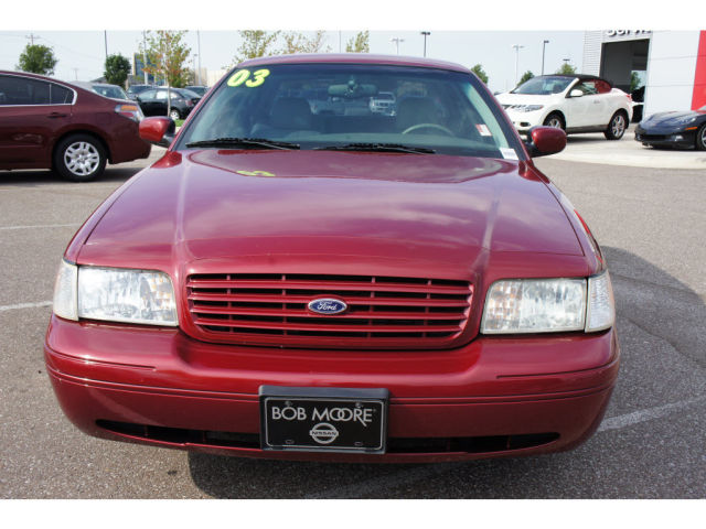 Red 2003 Ford Crown Victoria front view, with '03' sticker on windshield and 'Bob Moore' license plate frame