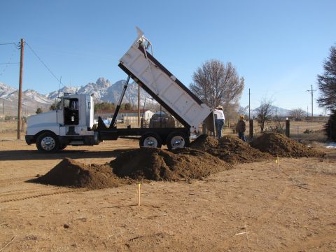 1995 Ford Bronco - Dump truck in a dirt lot with mountains in the background.