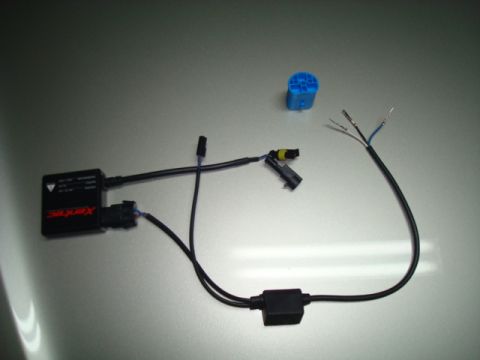 1995 Ford Bronco - HID ballast and wiring kit with various connectors and exposed wires, laid out on a metallic surface.