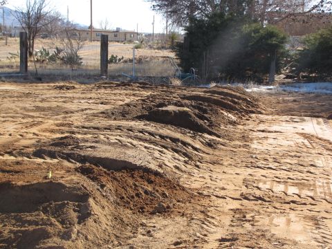 1995 Ford Bronco - A scene of disturbed earth with tire tracks, suggesting recent construction or landscaping activity.