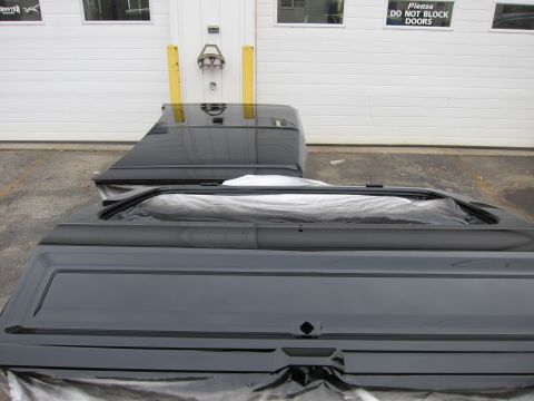 1987 Dodge 1500 - Two black truck bed sections, one with tailgate and side panel, are shown in front of a white garage door.