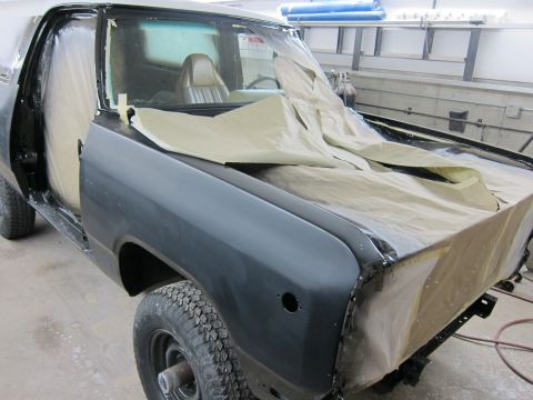 1987 Dodge 1500 - A truck is being prepped for painting in a workshop, with parts of the bodywork covered.