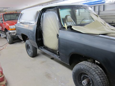 1987 Dodge 1500 - An SUV in a garage is being prepped for painting, with its doors open and interior covered.