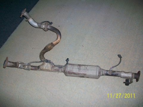 2000 Isuzu Vehicross - A used exhaust system catalytic converter with attached pipes and sensors is displayed on a flat surface.
