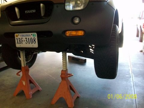 2000 Isuzu Vehicross - The front end of an Isuzu SUV is raised on jack stands, revealing the underside and a Virginia license plate.