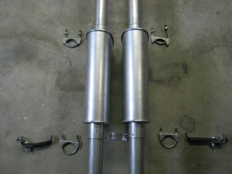 1979 Ford Bronco - Two exhaust mufflers and their associated clamps are laid out on a concrete surface.