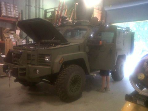 1990 Ford Bronco - Military truck with hood open and door ajar, inside a garage or workshop.