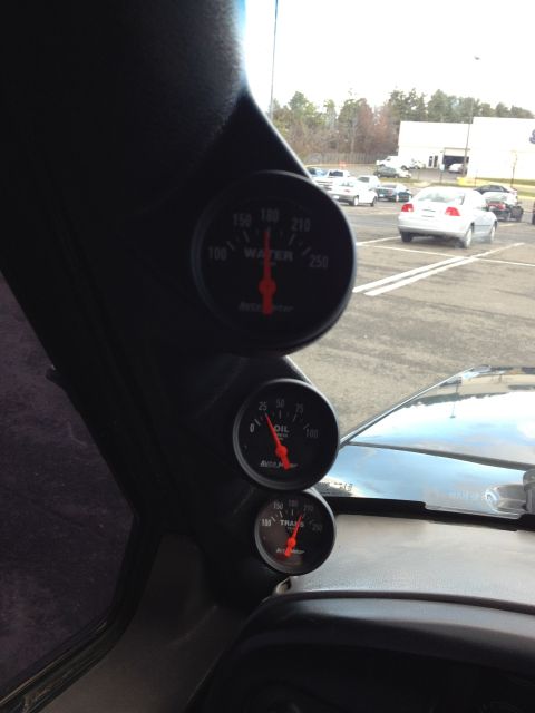 1995 Ford Bronco - Three aftermarket gauges are mounted on the A-pillar, showing water, oil, and transmission temperatures.