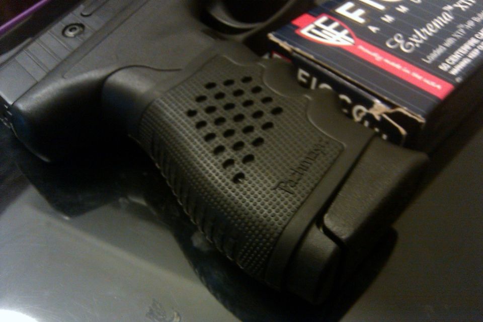 Black pistol grip with textured pattern and a box of Fiocchi Extrema ammunition