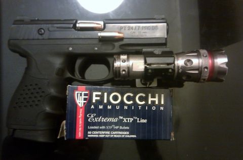 2000 Mercury Grand Marquis - A Taurus PT 24/7 PRO DS pistol is shown with a box of Fiocchi ammunition and a mounted flashlight.