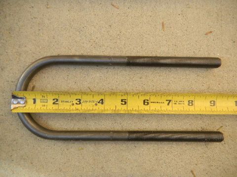 1997 Ford Ranger - A yellow Stanley tape measure is placed next to two metal U-bolts on a concrete surface.