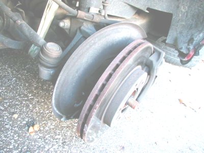1997 Ford Taurus - The image shows a close-up of a car's brake rotor and suspension components, with visible rust.