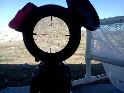 1996 Ford Bronco - View through a rifle scope at a shooting range, focusing on a distant field.