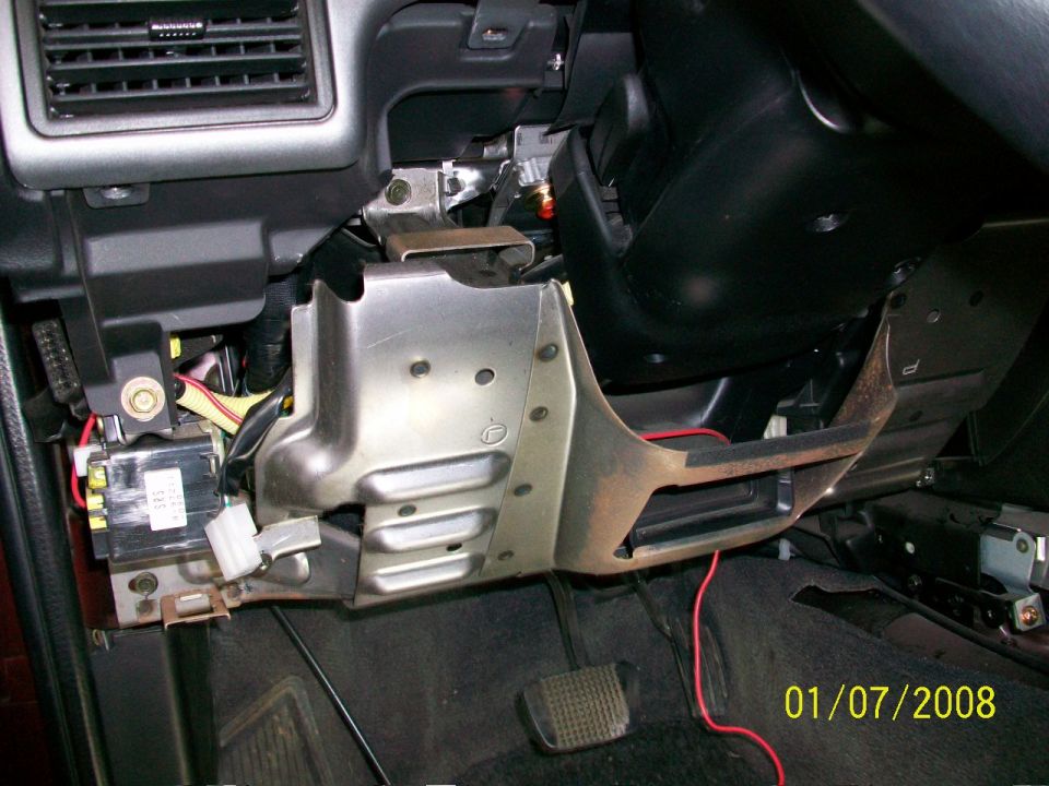 Car interior with exposed dashboard wiring, metal brackets, and black steering column. A date stamp reads 01/07/2008
