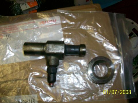 2000 Isuzu Vehicross - An automotive part, possibly a fuel injector, and a metal ring are shown in packaging.