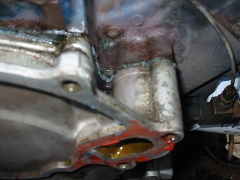 1992 Ford Bronco - Close-up of a leaking engine water pump gasket with visible fluid and sealant.