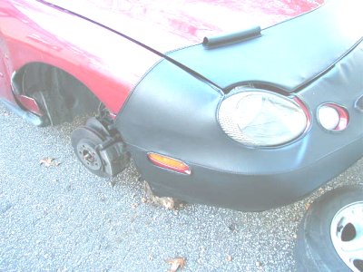 1997 Ford Taurus - This 1997 Ford Taurus is missing its front passenger wheel and has a car bra covering the front end.